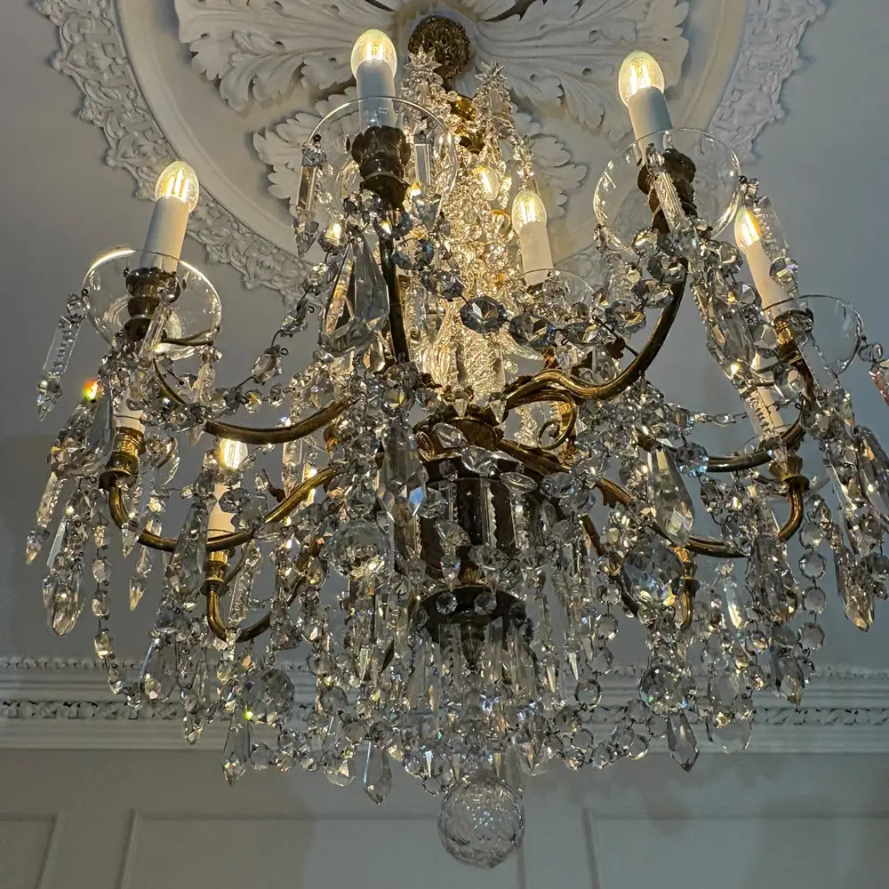 Crystal chandelier below an ornate ceiling rose